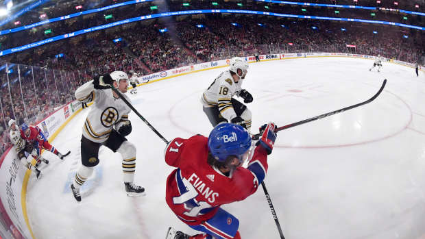 Nov 11, 2023; Montreal, Quebec, CAN; Montreal Canadiens forward Jake Evans (71) clears the puck away from Boston Bruins forward Pavel Zacha (18) during the overtime period at the Bell Centre. Mandatory Credit: Eric Bolte-USA TODAY Sports