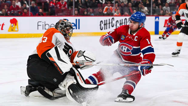 Mar 28, 2024; Montreal, Quebec, CAN; Philadelphia Flyers goalie Samuel Ersson (33) makes a save against Montreal Canadiens center Nick Suzuki (14) far away from his net during the second period at Bell Centre. Mandatory Credit: David Kirouac-USA TODAY Sports