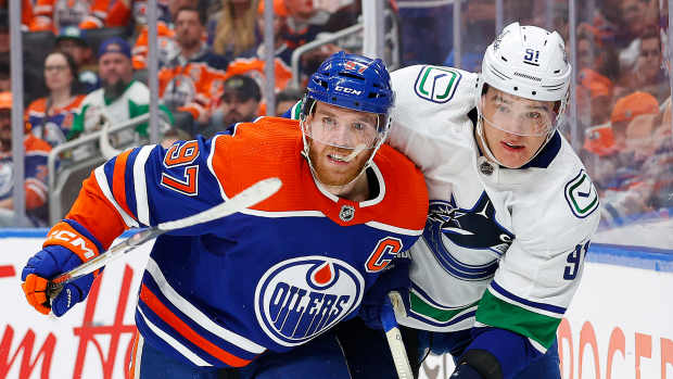 May 14, 2024; Edmonton, Alberta, CAN; Edmonton Oilers forward Connor McDavid (97) and Vancouver Canucks defensemen Nikita Zadorov (91) battle for position during the third period in game four of the second round of the 2024 Stanley Cup Playoffs at Rogers Place. Mandatory Credit: Perry Nelson-USA TODAY Sports