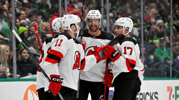 Mar 14, 2024; Dallas, Texas, USA; New Jersey Devils center Curtis Lazar (42) and center Chris Tierney (11) and left wing Kurtis MacDermid (23) and defenseman Simon Nemec (17) celebrates a goal scored by Tierney against the Dallas Stars during the first period at the American Airlines Center. Mandatory Credit: Jerome Miron-USA TODAY Sports
