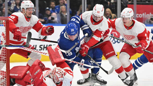 Toronto Maple Leafs forward Sam Lafferty (28) battles for a loose puck with Detroit Red Wings forward Marco Kasper (92) in front of goalie Alex Nedeljkovic (39) 