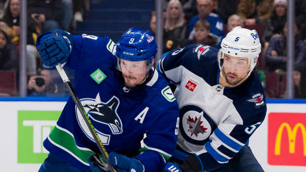 Mar 9, 2024; Vancouver, British Columbia, CAN; Vancouver Canucks forward J.T. Miller (9) battles with Winnipeg Jets defenseman Brenden Dillon (5) in the second period at Rogers Arena. Mandatory Credit: Bob Frid-USA TODAY Sports