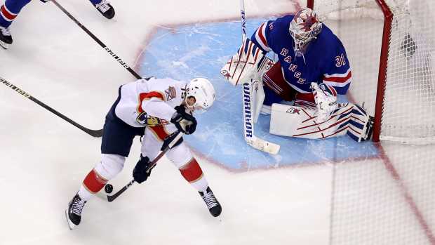 May 30, 2024; New York, New York, USA; Florida Panthers center Anton Lundell (15) shoots the puck between his own legs against New York Rangers goaltender Igor Shesterkin (31) and center Alex Wennberg (91) and defenseman Ryan Lindgren (55) during the third period of game five of the Eastern Conference Final of the 2024 Stanley Cup Playoffs at Madison Square Garden. Mandatory Credit: Brad Penner-USA TODAY Sports  