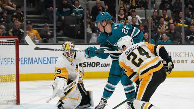 Jan 27, 2025; San Jose, California, USA; San Jose Sharks left wing Fabian Zetterlund (20) shoots against Pittsburgh Penguins defenseman Matt Grzelcyk (24) and goalie Alex Nedeljkovic (39) in the second period at SAP Center at San Jose. Mandatory Credit: David Gonzales-Imagn Images  