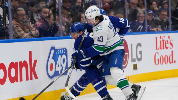 Jan 11, 2025; Toronto, Ontario, CAN; Vancouver Canucks defenseman Quinn Hughes (43) checks Toronto Maple Leafs forward John Tavares (91) during the third period at Scotiabank Arena. Mandatory Credit: John E. Sokolowski-Imagn Images