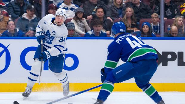 Feb 8, 2025; Vancouver, British Columbia, CAN; Toronto Maple Leafs forward Auston Matthews (34) shoots in front of Vancouver Canucks forward Elias Pettersson (40) in the third period at Rogers Arena. Mandatory Credit: Bob Frid-Imagn Images