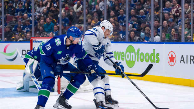 Feb 8, 2025; Vancouver, British Columbia, CAN; Vancouver Canucks defenseman Marcus Pettersson (29) stick checks Toronto Maple Leafs forward John Tavares (91) in the second period at Rogers Arena. Mandatory Credit: Bob Frid-Imagn Images