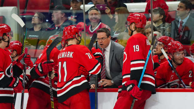 Apr 4, 2019; Raleigh, NC, USA; Carolina Hurricanes assistant coach Dean Chynoweth talks to center Lucas Wallmark (71) and defenseman Dougie Hamilton (19) during a time out against the New Jersey Devils at PNC Arena. The Carolina Hurricanes defeated the New Jersey Devils 3-1. 