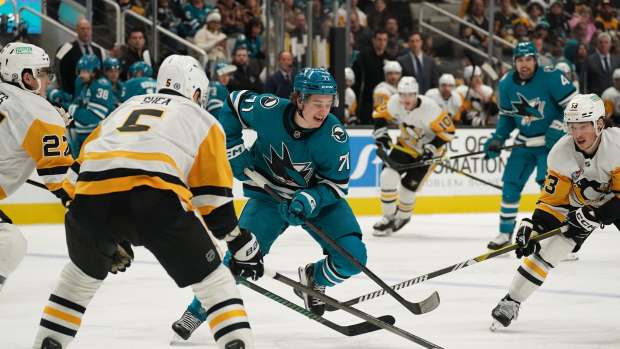 Jan 27, 2025; San Jose, California, USA; San Jose Sharks center Macklin Celebrini (71) is defended by Pittsburgh Penguins defenseman Ryan Graves (27), defenseman Ryan Shea (5) and center Philip Tomasino (53) in the second period at SAP Center at San Jose. Mandatory Credit: David Gonzales-Imagn Images