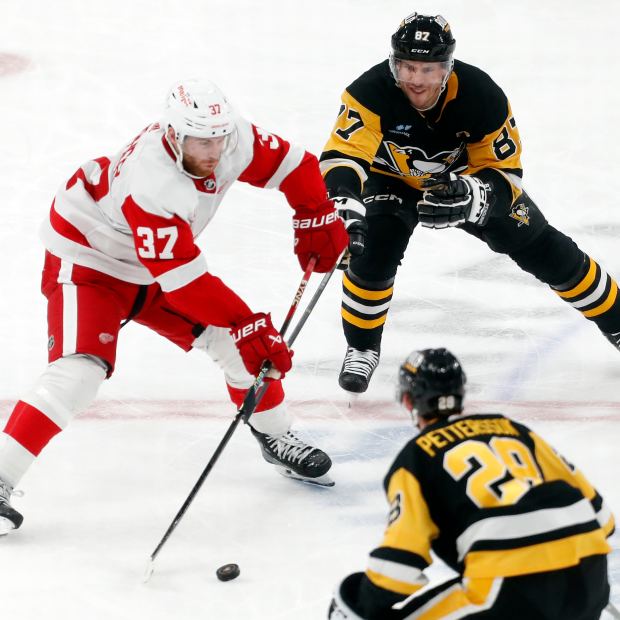 Detroit Red Wings left wing J.T. Compher (37) passes the puck as Pittsburgh Penguins center Sidney Crosby (87) and defenseman Marcus Pettersson (28) defend