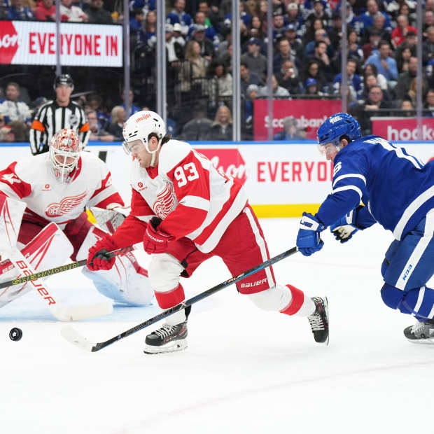 Detroit Red Wings right wing Alex DeBrincat (93) battles for the puck with Toronto Maple Leafs right wing Mitch Marner (16)