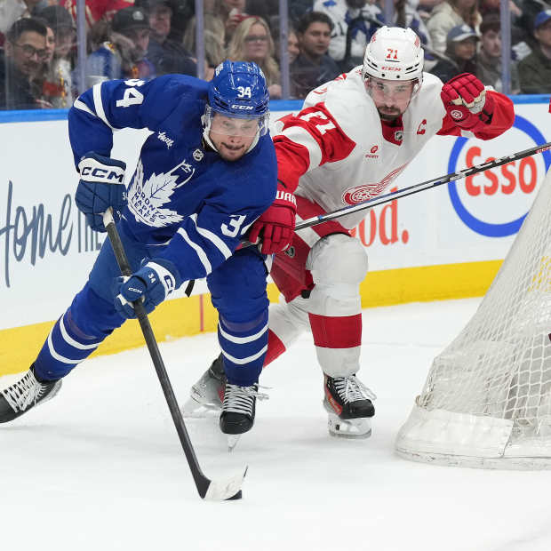 Toronto Maple Leafs center Auston Matthews (34) battles for the puck behind the net with Detroit Red Wings center Dylan Larkin (71)