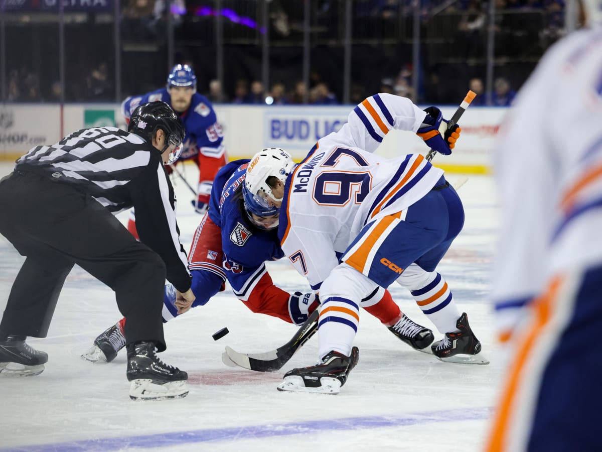 PHOTO: Kings mascot offers Oilers 'Hockey for Dummies' book during blowout