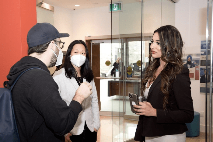 A visitor talks to Courtney Szto and Amrit Gill.