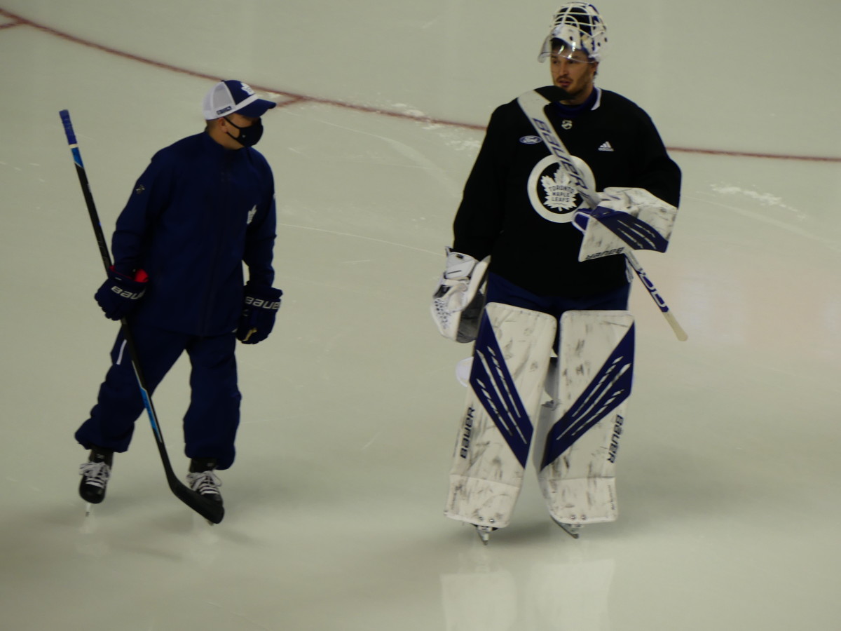Michael Hutchinson (right) skating with Leafs goaltending coach Steve Briere (left) before practice begins at Scotiabank Saddledome.