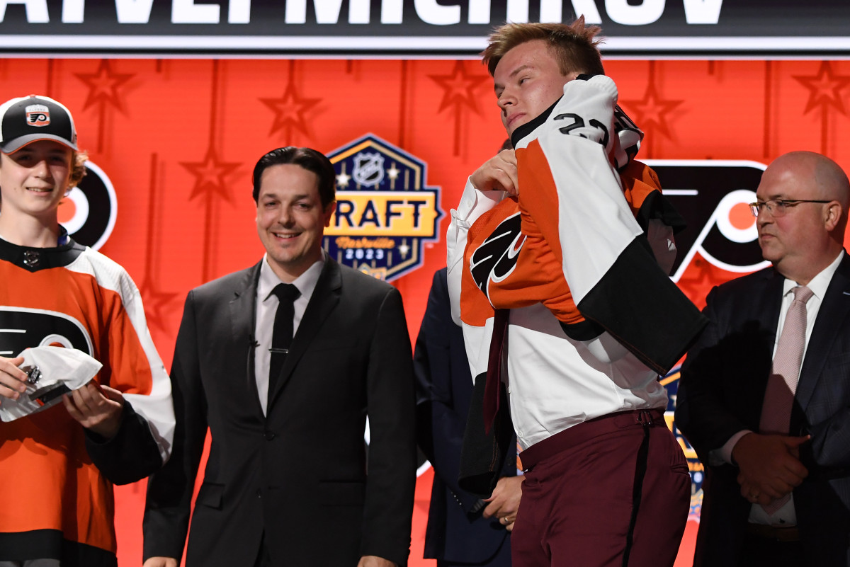 Philadelphia Flyers draft pick Matvei Michkov puts on his sweater after being selected with the seventh pick in round one of the 2023 NHL Draft at Bridgestone Arena.