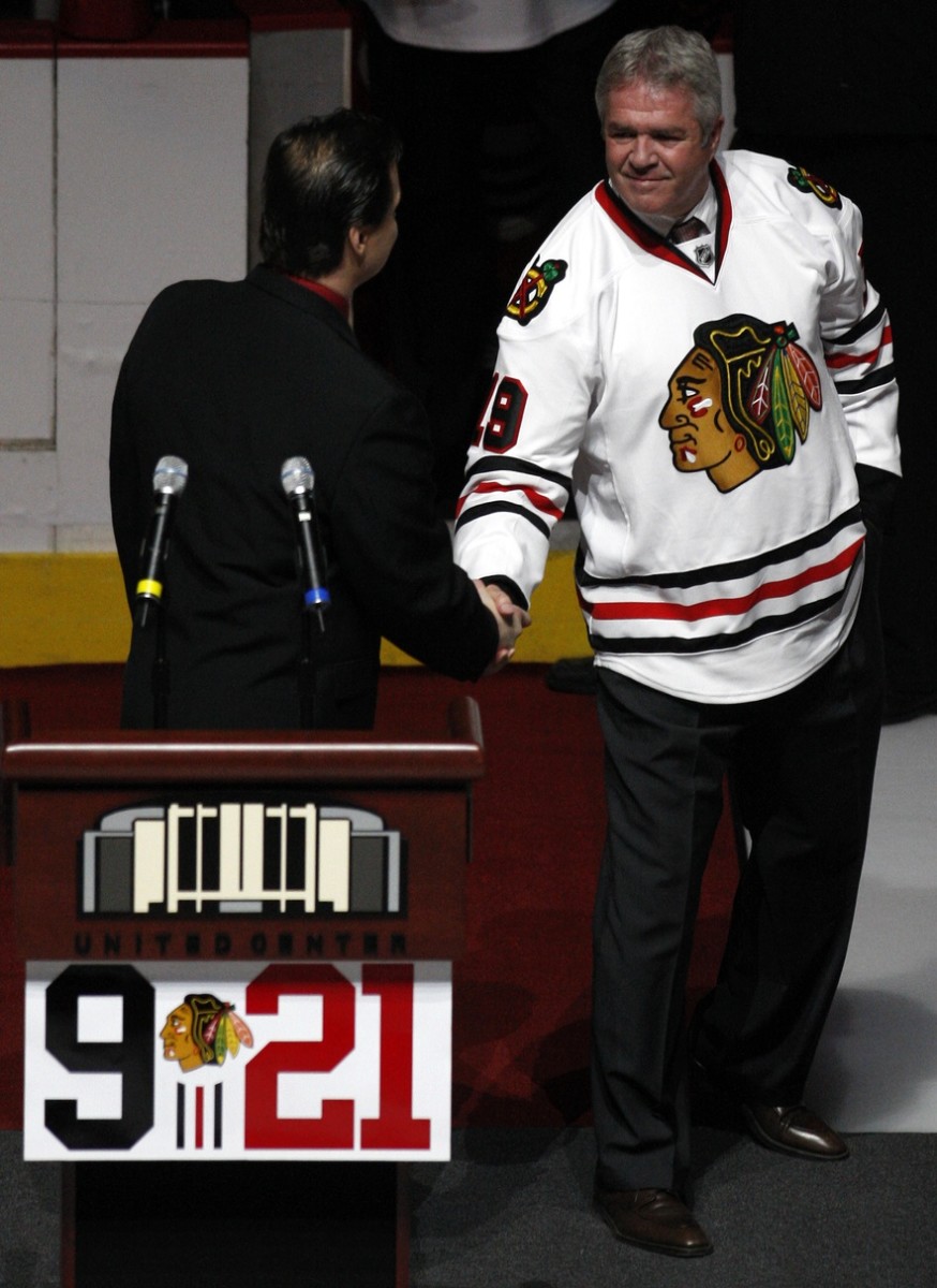 Dale Tallon (right) shakes hands with fellow former Blackhawk Eddie Olczyk in a ceremony in May 2008