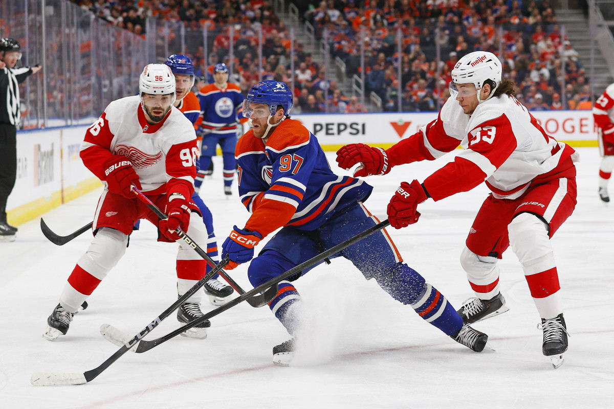 Feb 13, 2024; Edmonton, Alberta, CAN; Edmonton Oilers forward Connor McDavid (97) protects the puck from Detroit Red Wings defensemen Moritz Seider (53) and defensemen Jake Walman (96) at Rogers Place